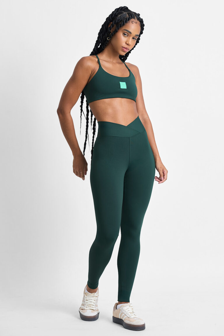 LEGGING KALI FLORESTA: Mulher vestindo conjunto esportivo verde, incluindo top e legging.