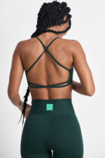 LEGGING KALI FLORESTA: Legging verde escura e top esportivo com tiras cruzadas nas costas.