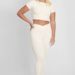 LEGGING KALI MACADÂMIA: Legging cor macadâmia, parte de um conjunto atlético com top e lenço na cabeça.