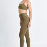 LEGGING KALI SOFT SAVANA: Legging verde oliva com top esportivo e tênis brancos.