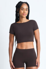Short Ema Cacau: Conjunto marrom de top cropped e shorts, ideal para exercícios ou uso casual.
