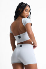 Short Ema Lunar: Conjunto esportivo azul claro com top cropped e shorts justos.