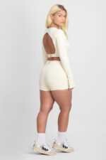 Short Ema Macadâmia: Conjunto atlético cor creme com shorts e top cropped de manga longa.
