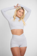 Short Yani Lunar: roupa de ginástica feminina cinza, top cropped de manga comprida e shorts esportivos.