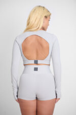 Short Yani Lunar: conjunto de treino cinza com shorts e blusa de manga comprida com abertura nas costas.