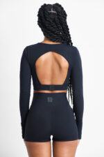 Mulher de costas usando SHORT YANI SOFT NANQUIM preto, conjunto de shorts e top esportivo com costas abertas.
