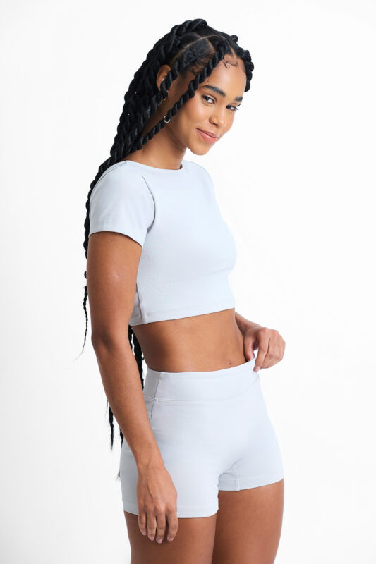 Top Amélia Lunar: Conjunto feminino azul claro de top cropped e shorts para exercícios.