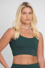 Mulher usando Top Noma Floresta verde. Roupa esportiva confortável e estilosa.