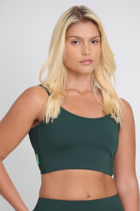 Mulher usando Top Noma Floresta verde. Roupa esportiva confortável e estilosa.