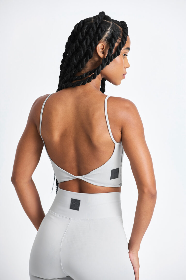 Top Noma Lunar: Top esportivo cinza claro com design moderno e costas abertas.