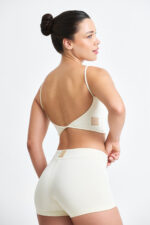 Top Noma Macadâmia: Top esportivo cor creme, costas abertas, ideal para treinos.
