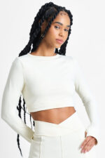 TOP AYMÉ MACADÂMIA: Top cropped de manga comprida cor macadâmia, ideal para treinos ou looks casuais.