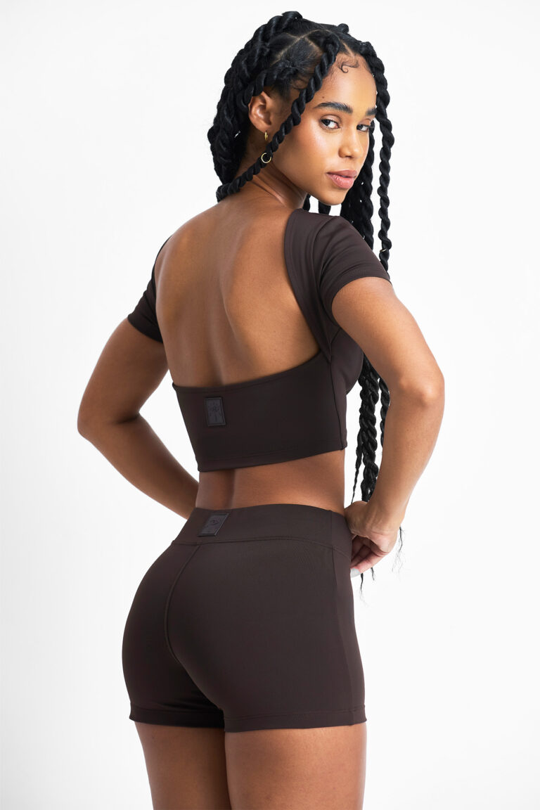 TOP AMÉLIA CACAU: Top cropped marrom com design moderno e costas abertas, ideal para treinos e looks casuais.