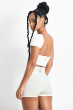 Top Amélia Macadâmia: Top esportivo cor creme e shorts combinando, ideal para treino.