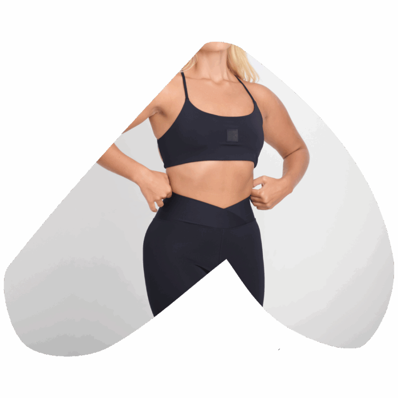 Mulher vestindo conjunto fitness YAMONÉ preto, top e legging. Moda esportiva.