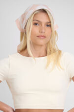 Mulher usando Lenço Atena. Lenço Atena é um acessório de moda estiloso.
